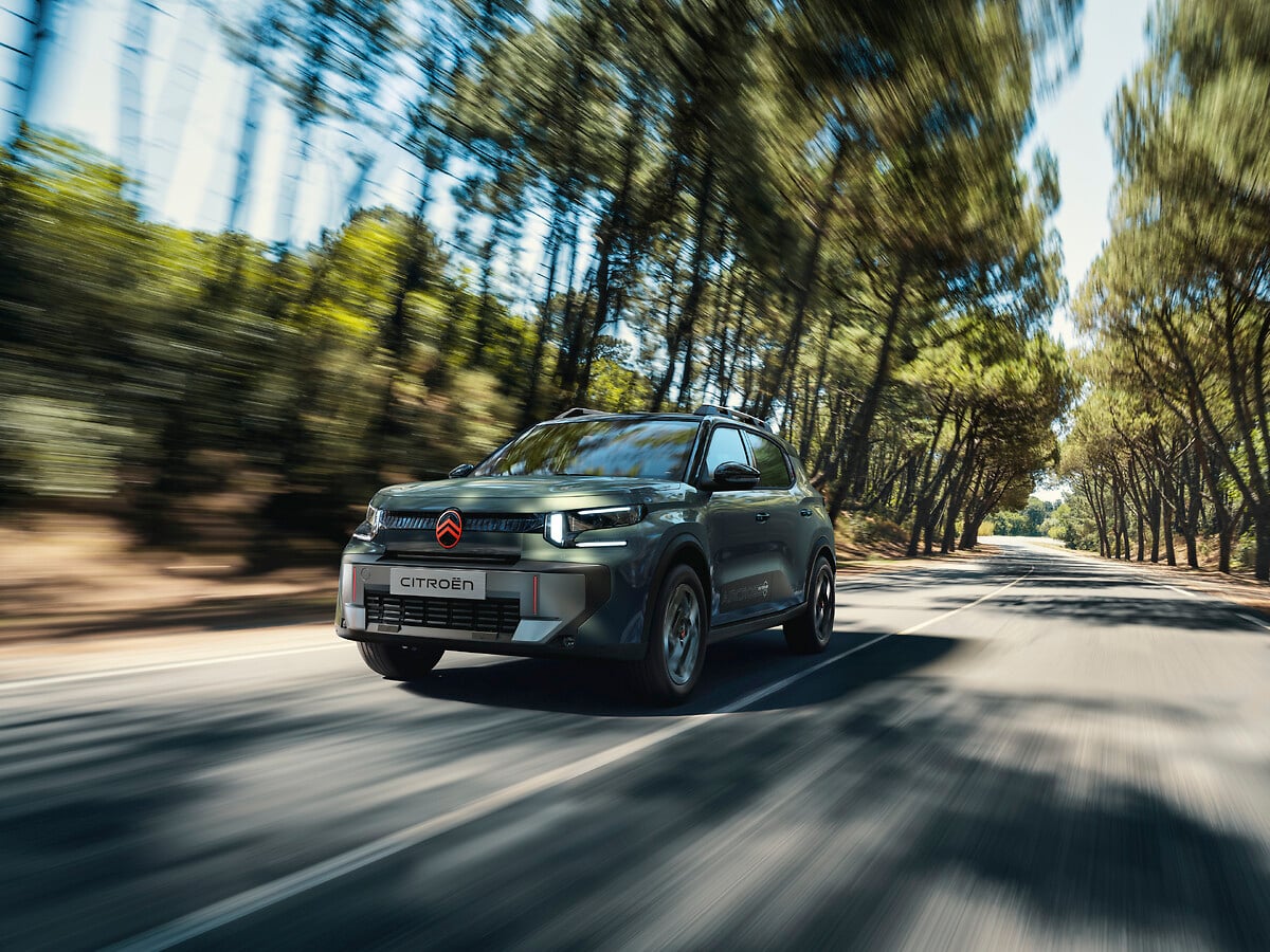 Citroën C3 Aircross Outdoor in Sequoia Green driving on a tree-lined road